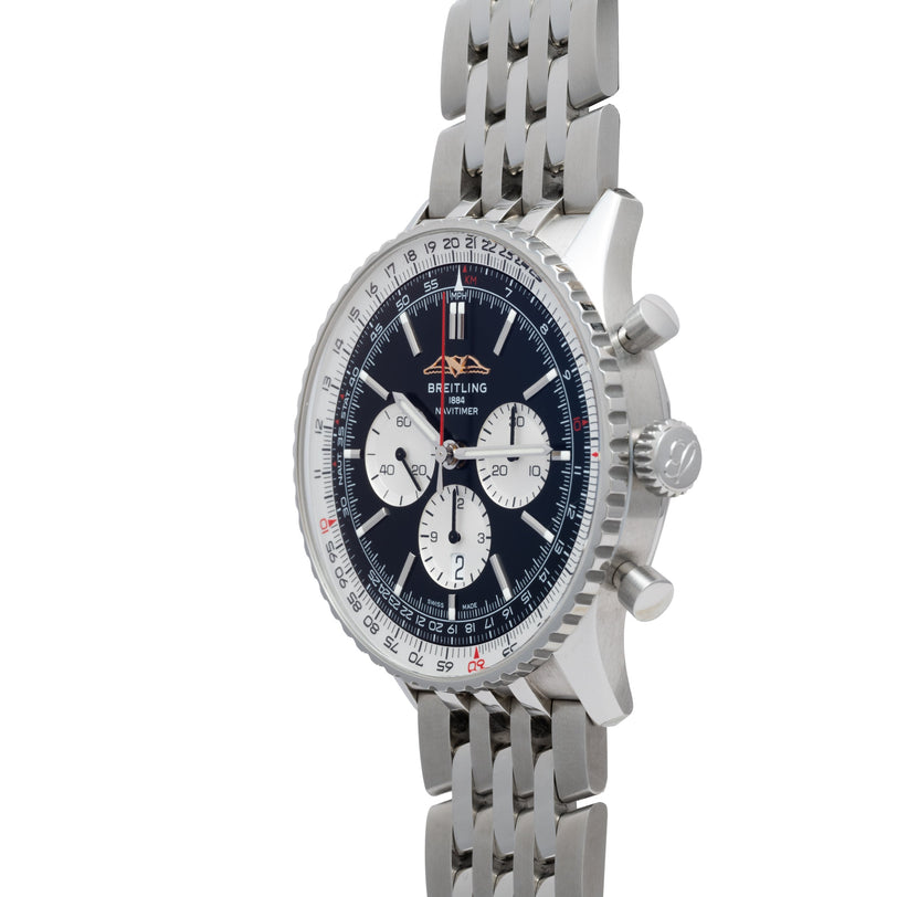 A Breitling Navitimer 46 chronograph watch featuring a silver case, blue dial, and metal link band, displayed at an angle.