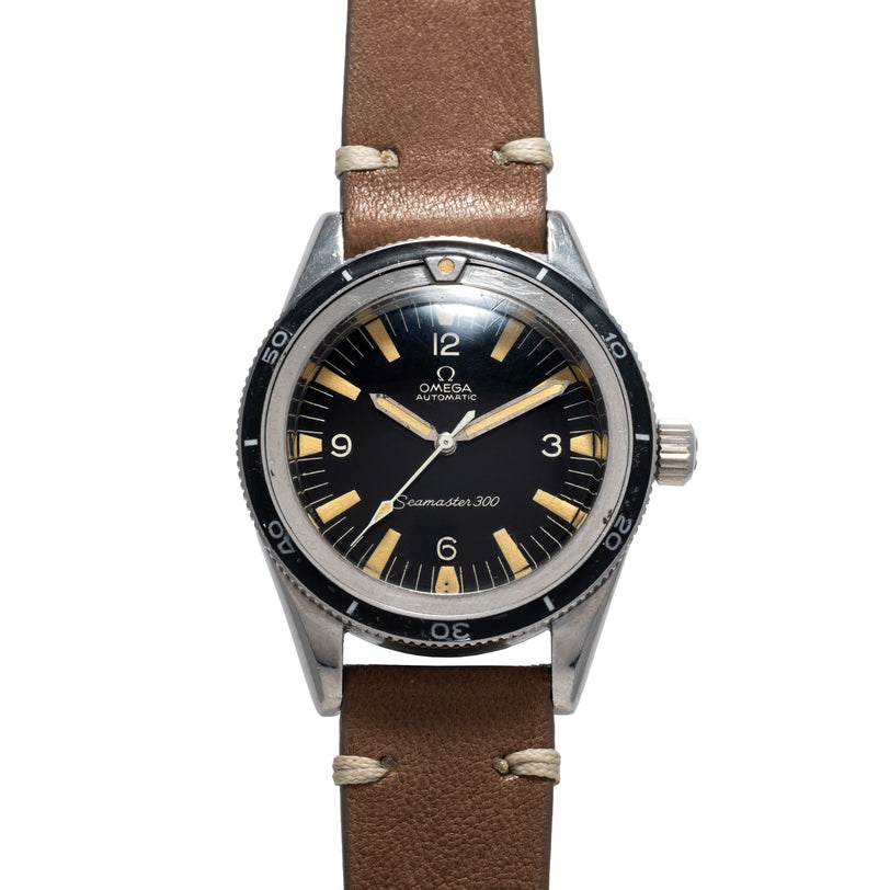 The OMEGA Seamaster 300, featuring a black dial and brown leather strap, is displayed from the front.