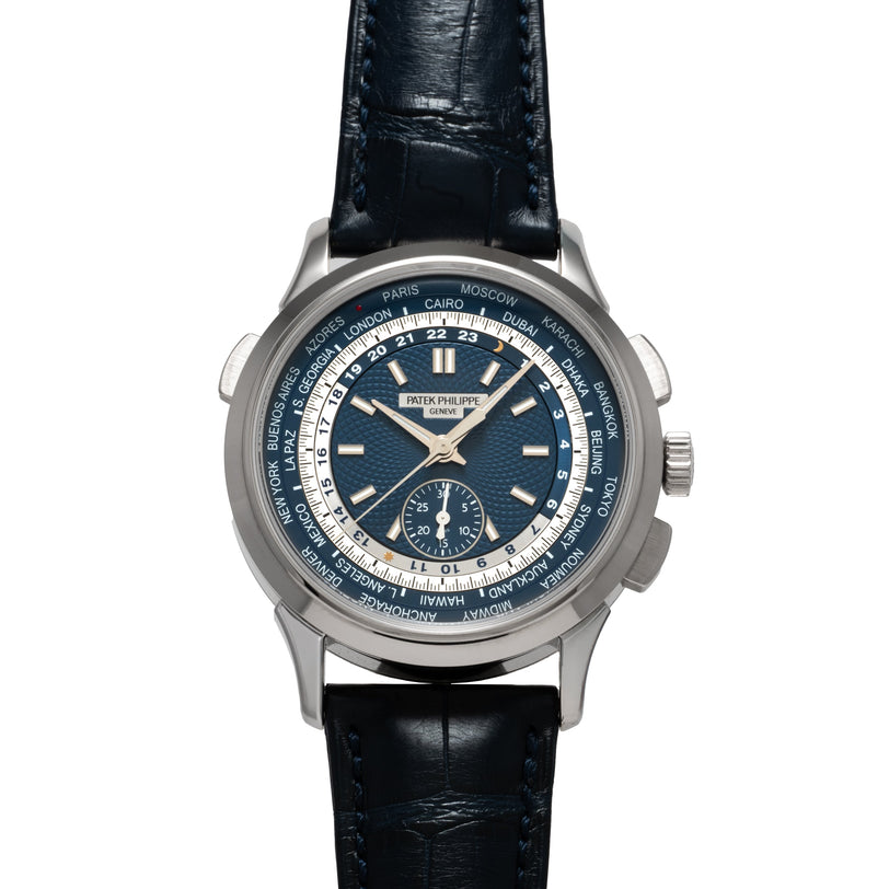 The Patek Philippe World Time Chronograph is a luxury wristwatch featuring a blue leather strap and multiple city names displayed around the watch face.
