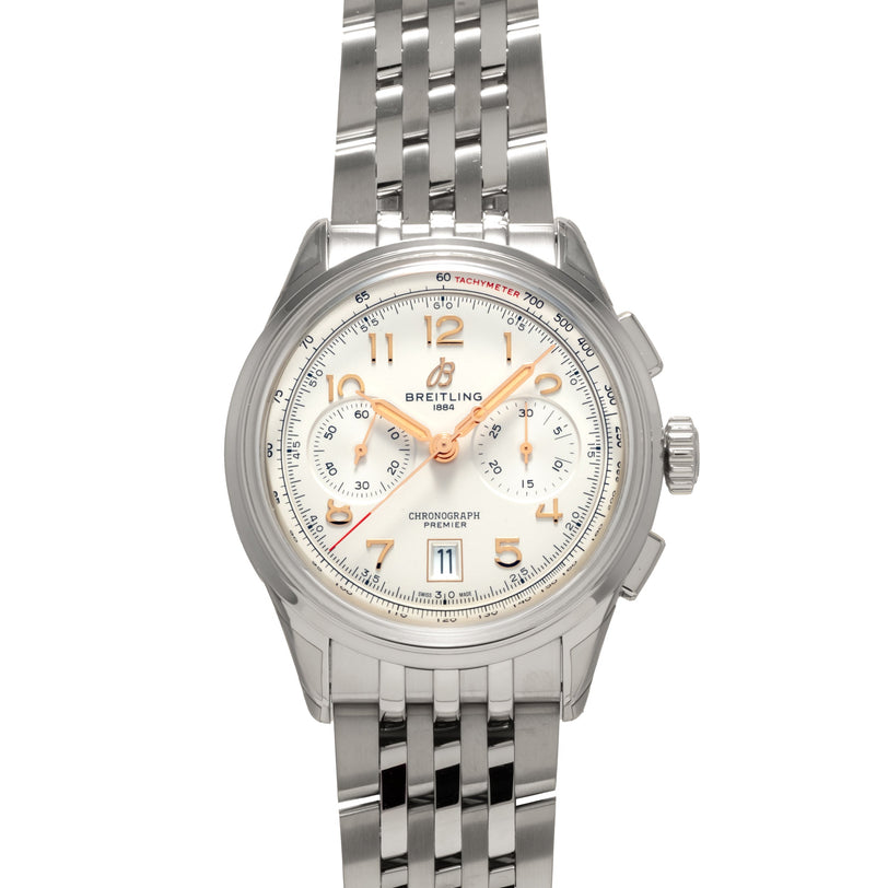 The Breitling B01 Premier Chronograph 42 is a silver wristwatch with a metal band and a white dial accented by gold hour markers.