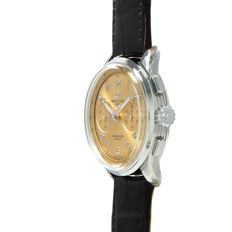 Breitling Premiere B09 Chronograph 40 wristwatch with a gold face and black leather strap, displayed from a side angle on a white background.