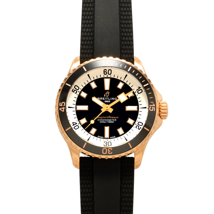 Breitling Superocean Automatic 42 gold dive watch with a black dial, white markers, and a black textured strap, viewed from above.