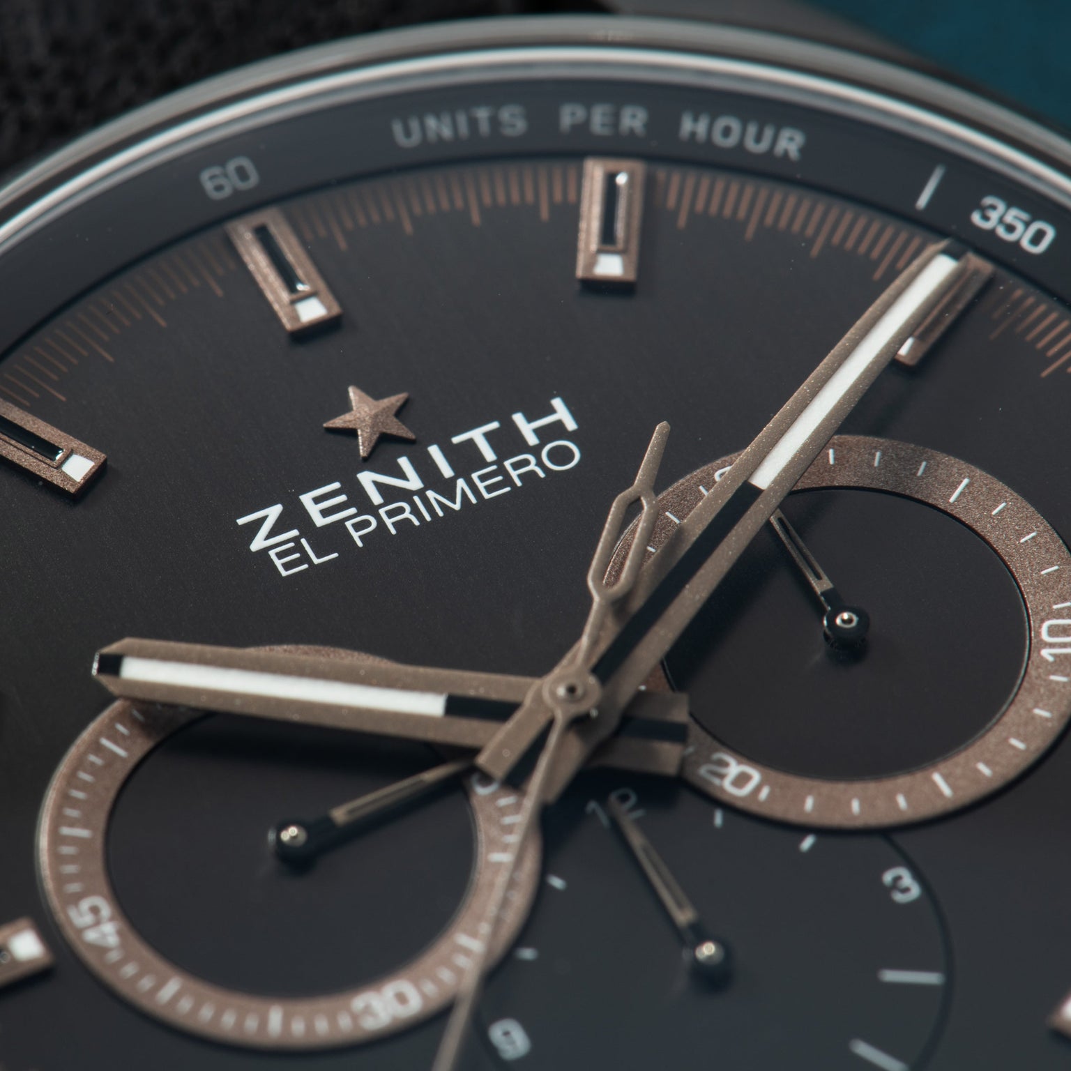 Zenith El Primero chronograph watch with black dial, metallic hands, and dual subdials displaying "Units Per Hour" scale.