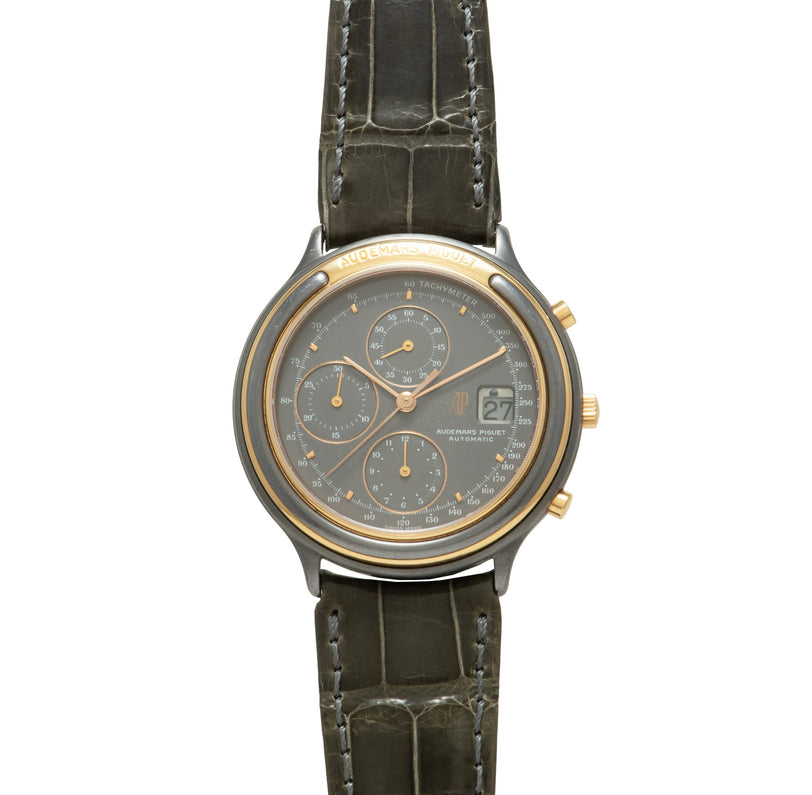 Two-tone chronograph watch with dark gray dial, three subdials, date window, and crocodile leather strap with white stitching