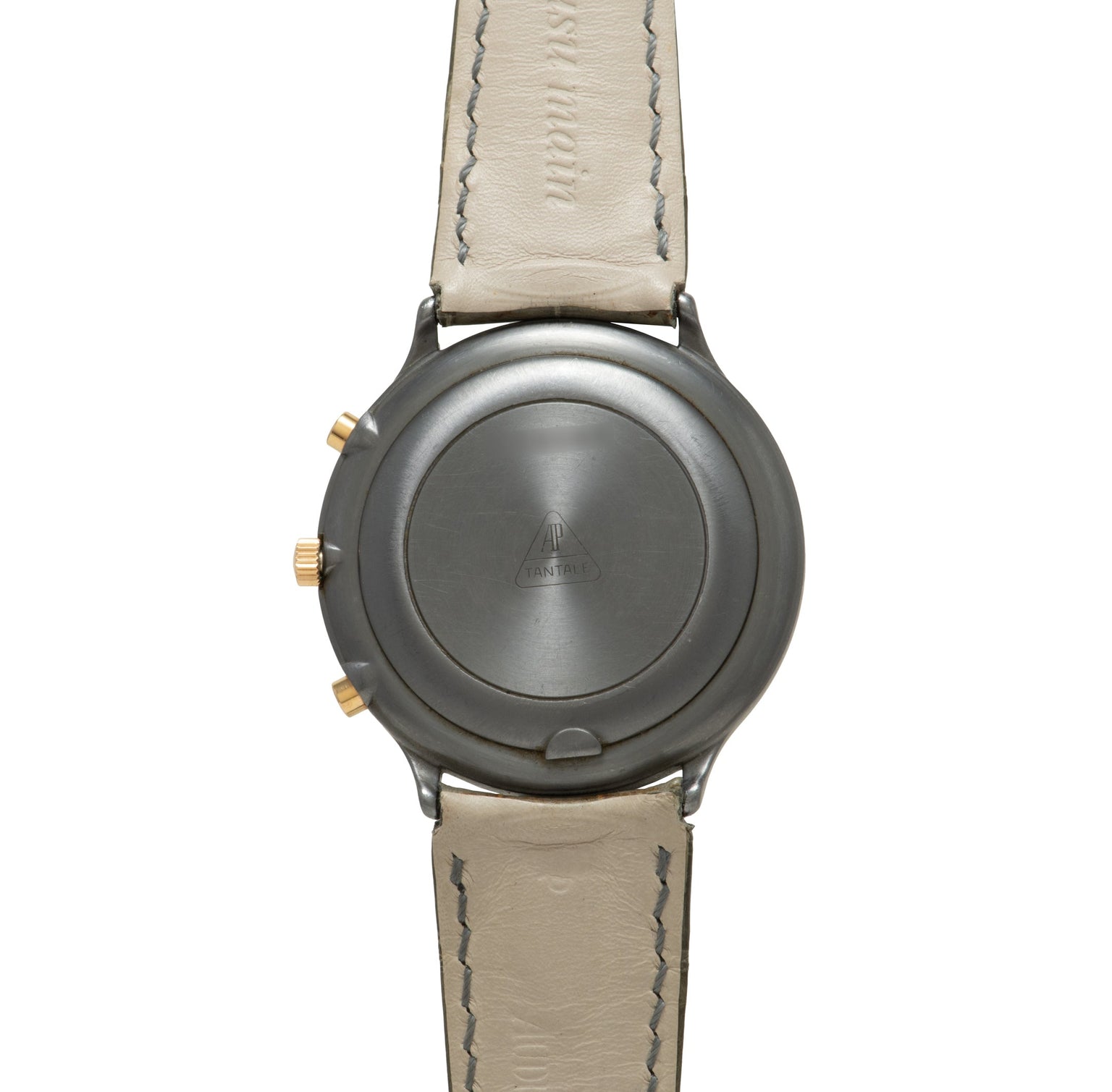 Titanium chronograph watch with gray dial, gold pushers, and beige leather strap with contrast stitching.