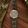 Audemars Piguet Huitième chronograph with two-tone case, dark dial, three subdials, and crocodile leather strap.