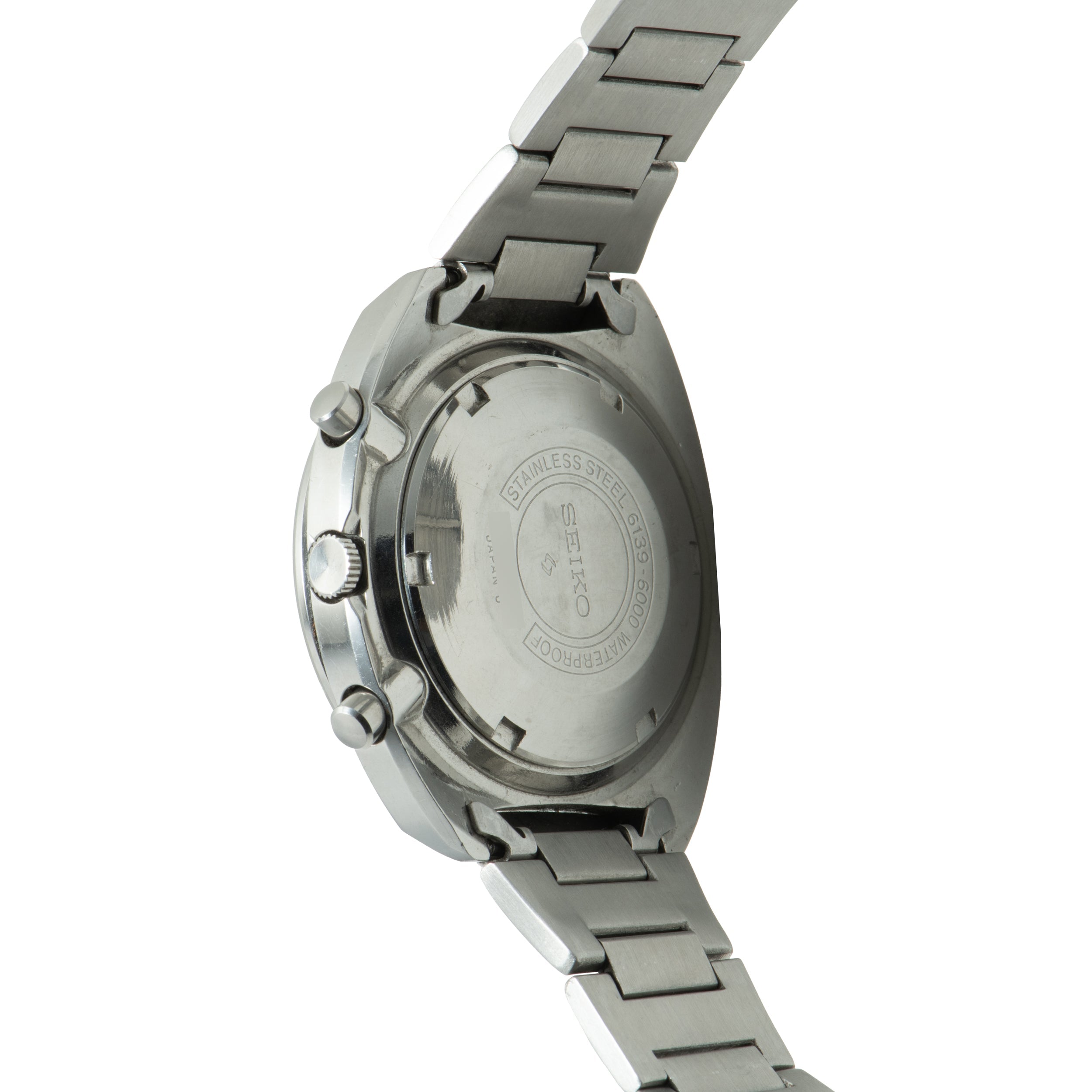 Seiko chronograph watch with stainless steel case and bracelet, shown from rear view displaying caseback with engraved text.