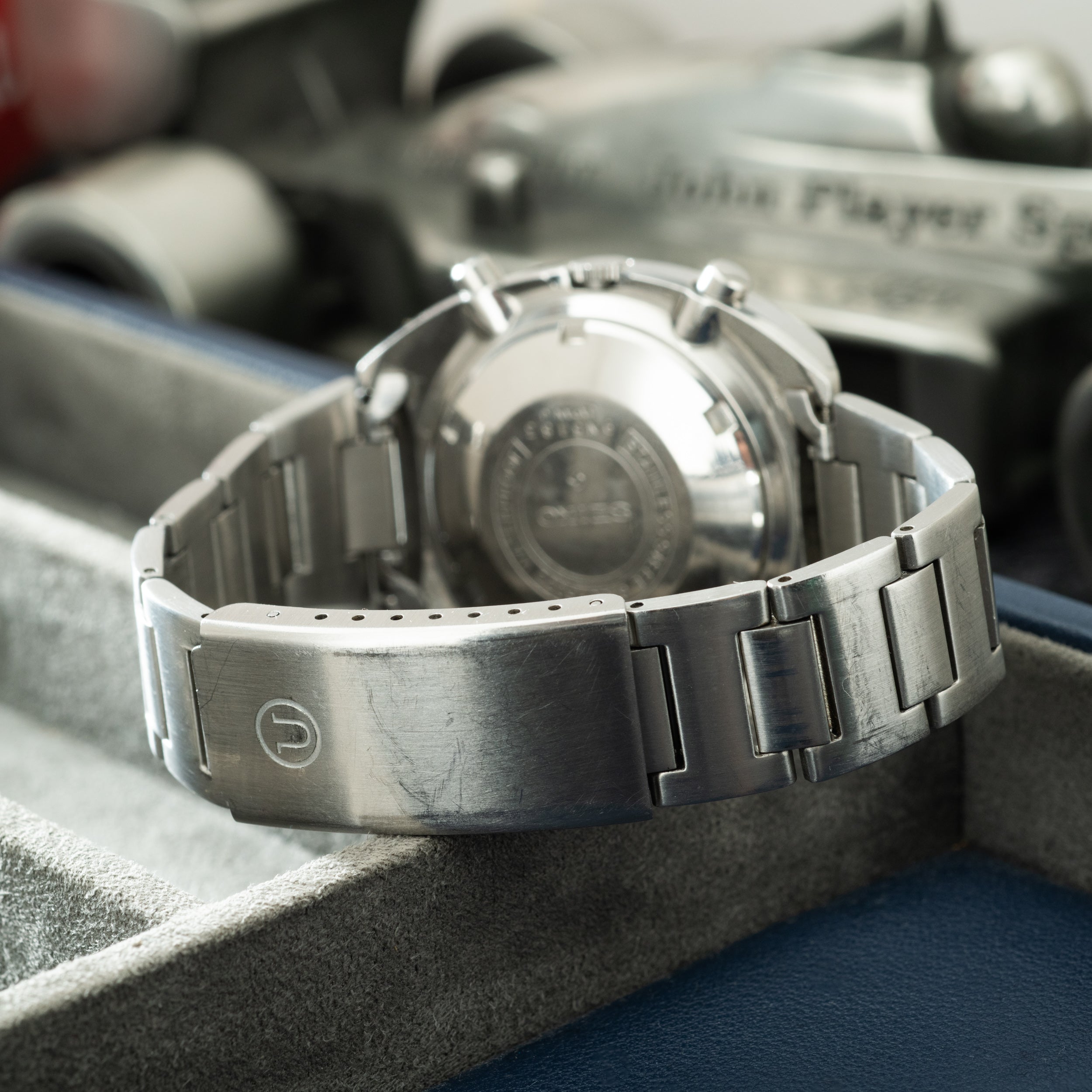 Seiko chronograph watch with stainless steel bracelet and dial, displayed on its back showing case back engraving.