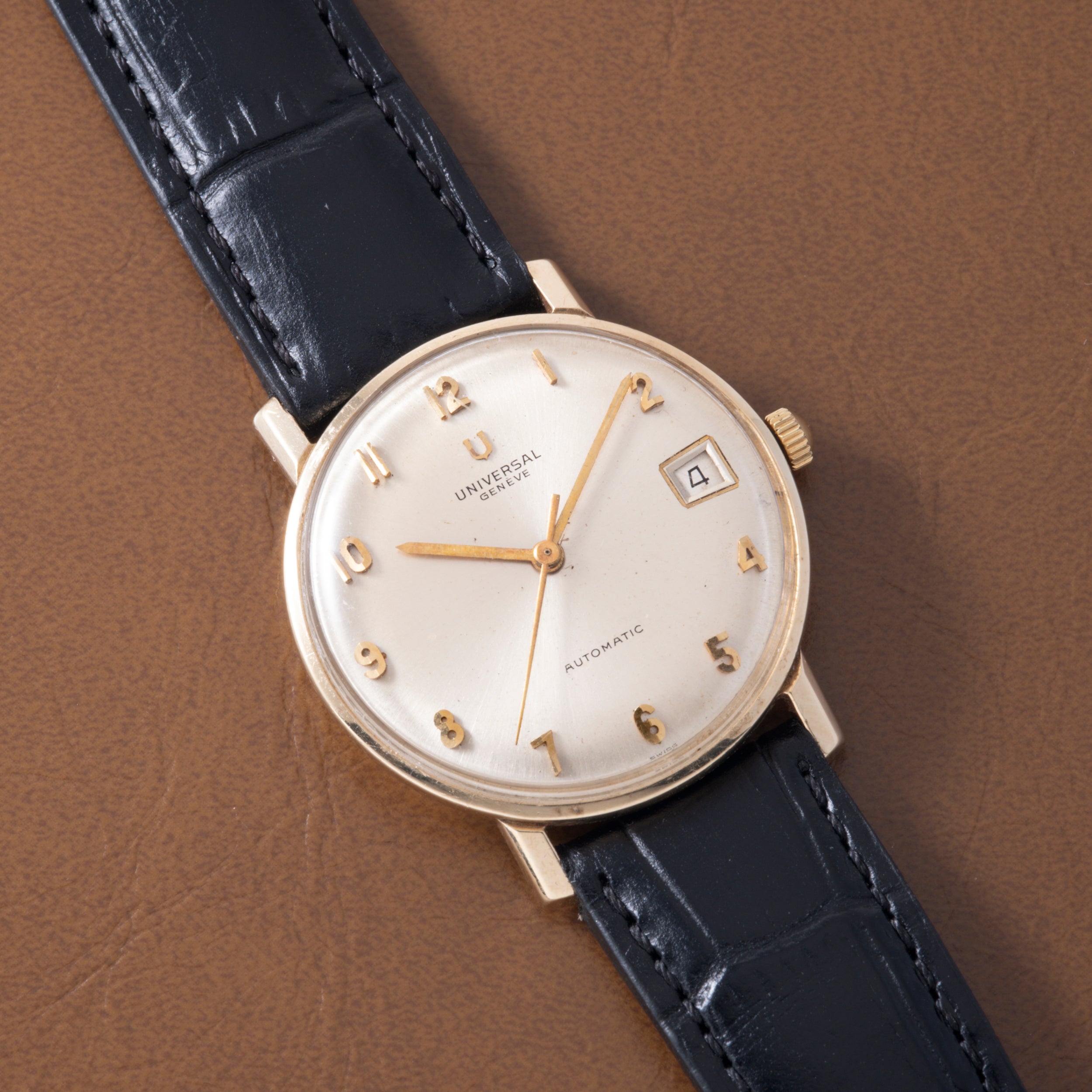 Universal Geneve automatic wristwatch with cream dial, gold applied numerals and hands, date window, and black crocodile leat