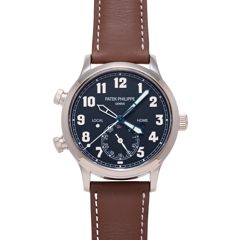Patek Philippe Calatrava Pilot Travel Time watch with dark dial, dual time zones, brown leather strap, and steel case.