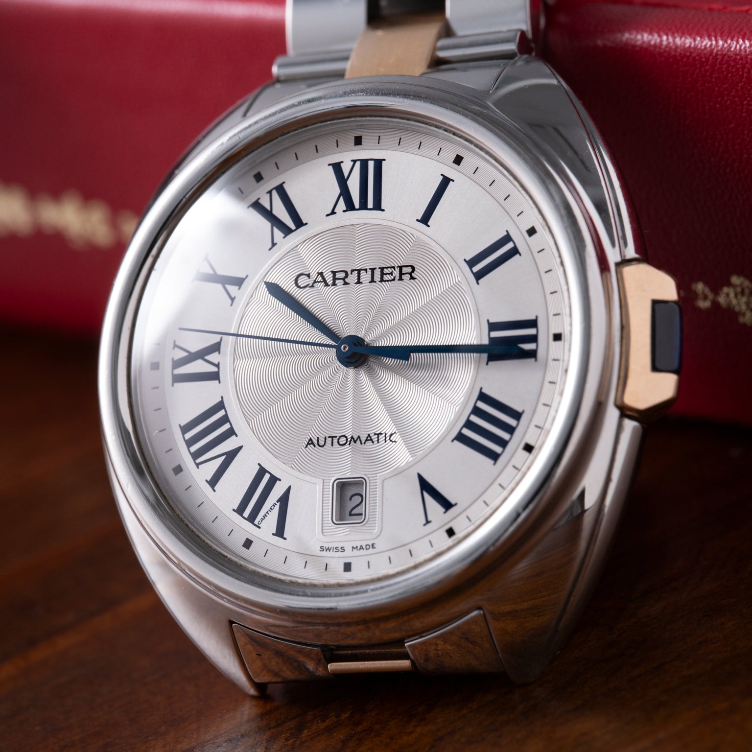 Cartier Clé de Cartier automatic watch with silver case, two-tone bracelet, white dial, and Roman numerals.