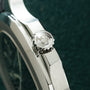 Silver-tone sports watch with octagonal bezel featuring cross motif and white rubber strap.