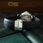 Patek Philippe Aquanaut watch with black rubber strap and cushioned steel case displaying cross motif on clasp.