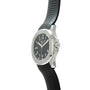 Stainless steel watch with black dial, Arabic numerals, and black rubber strap with quilted pattern.