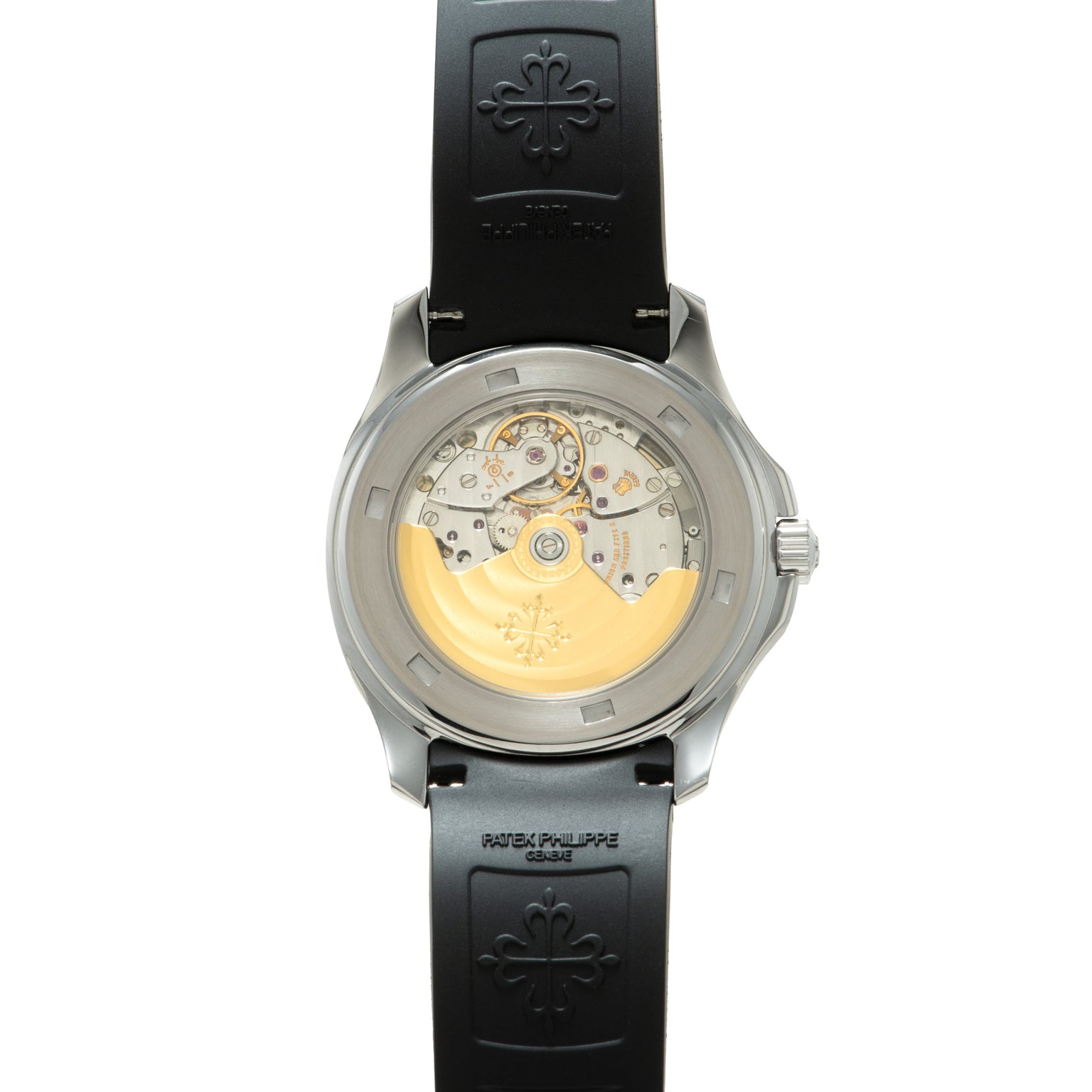 Steel watch with black rubber strap showing exposed golden movement and cross emblem on caseback.