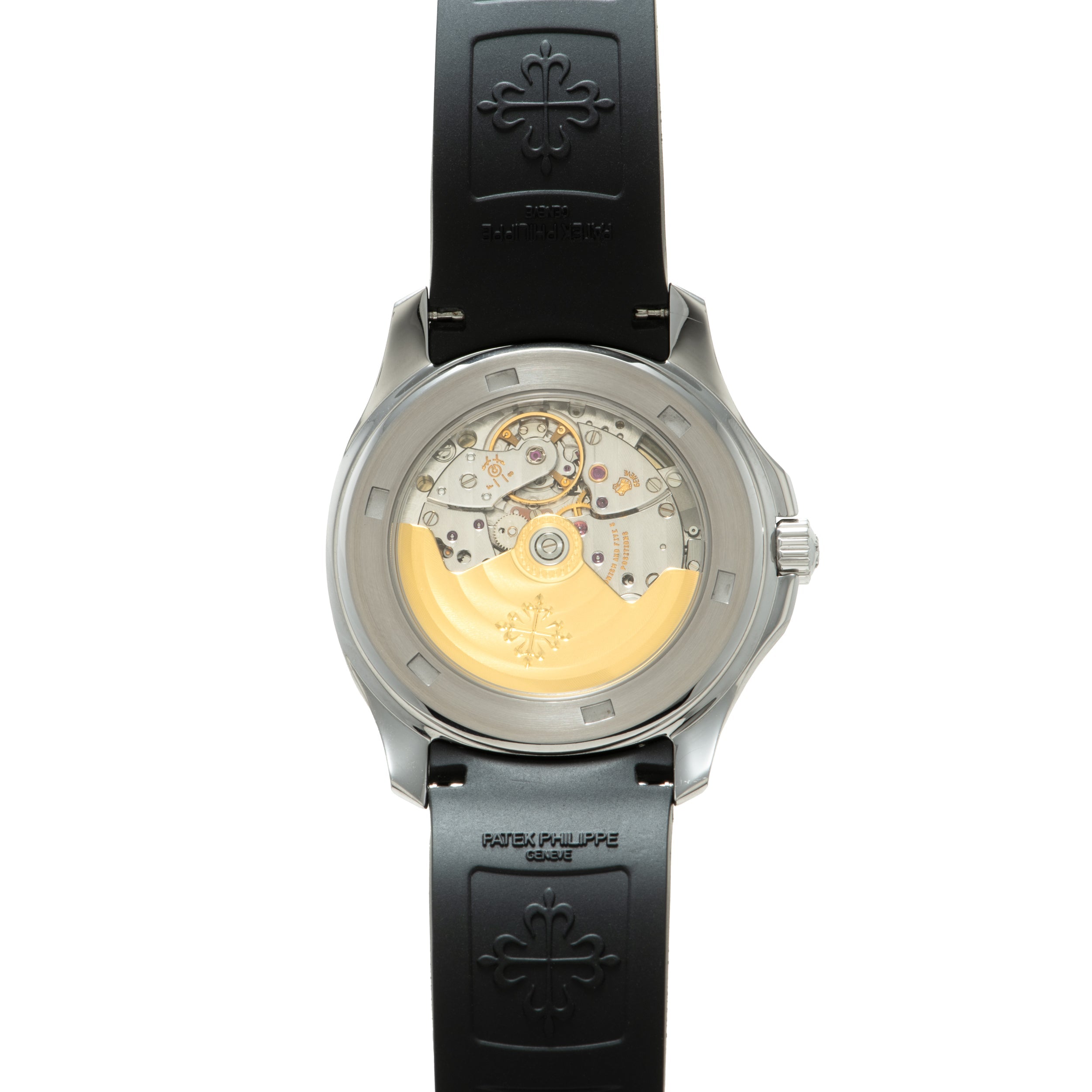 Steel watch with black rubber strap showing exposed golden movement and cross emblem on caseback.