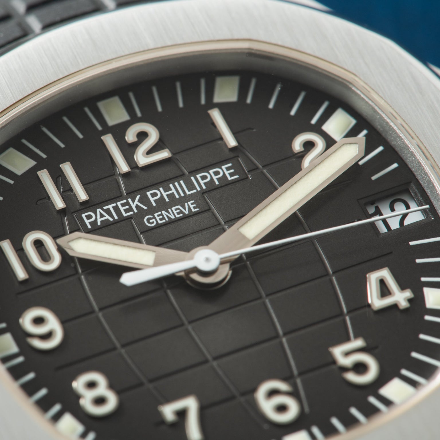 Stainless steel watch with black dial, luminous hands and hour markers, showing Patek Philippe Geneve branding.