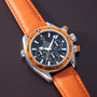 Omega Seamaster Planet Ocean chronograph watch with orange bezel, black dial, and orange leather strap.