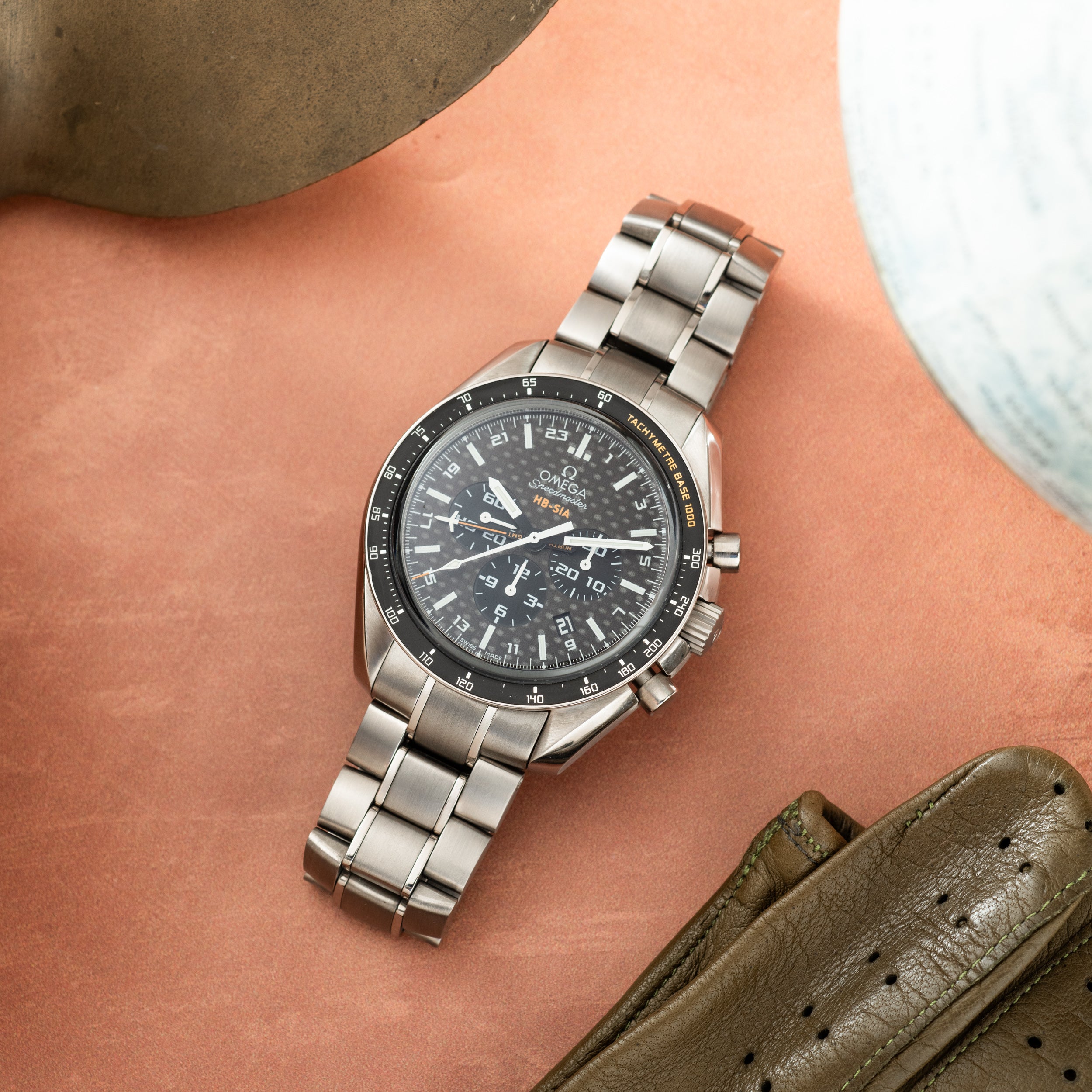 Titanium chronograph watch with dark dial, tachymeter bezel, and linked bracelet worn on wrist.