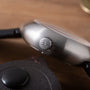 Brushed metal Ikepod Megapod watch with hourglass-shaped crown and black leather strap detail visible.