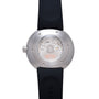 Stainless steel round watch with visible mechanical movement on caseback, black rubber strap, and crown on side.
