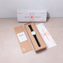 Ikepod Megapod Hourglass watch with white dial and black leather strap displayed with packaging and documentation.