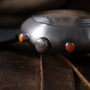 Ikepod Chronopod 'Hey Joe' 014 watch with brushed steel case, orange accents on crown and pushers, and black leather strap.
