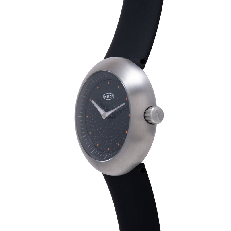 Ikepod Duopod Dots 004 watch with brushed steel case, black dial with orange dot indices, and black rubber strap.