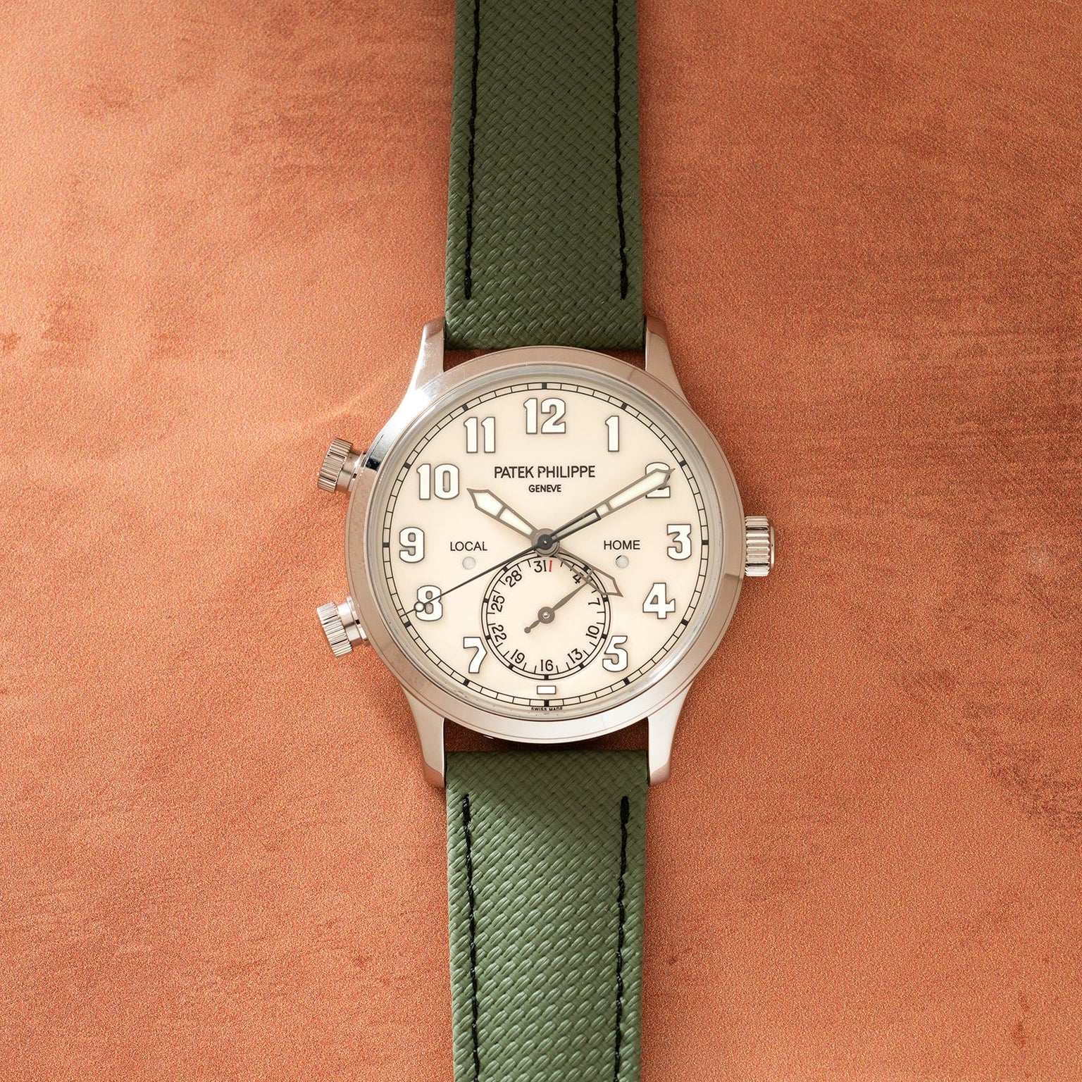 Silver-tone watch with cream dial, dual time zones labeled "Local" and "Home," small subdial, Arabic numerals, and green text