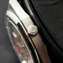 Hexagonal steel case back with AP logo engraving, part of luxury watch shown against black textile.