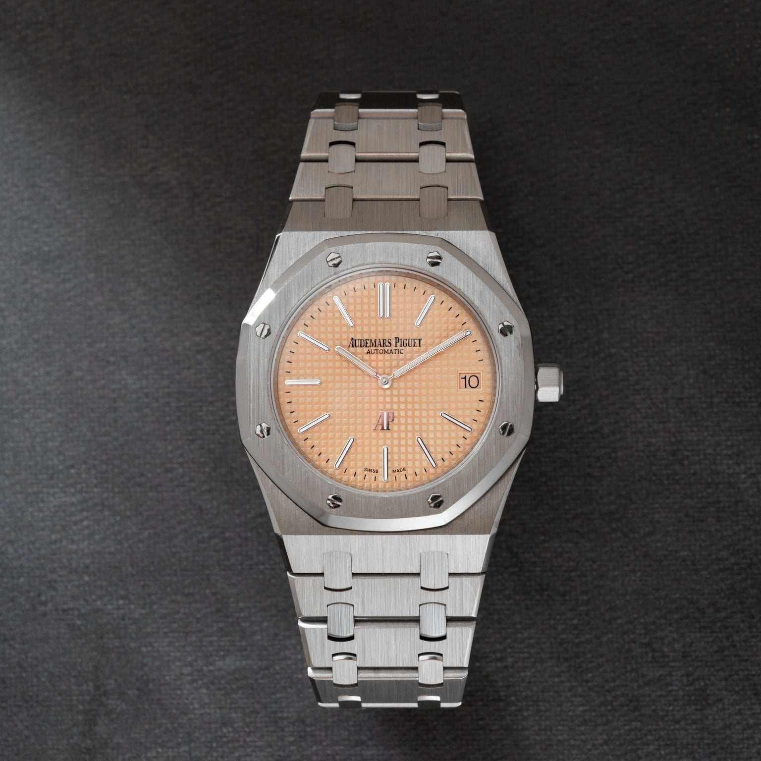 Stainless steel Audemars Piguet Royal Oak watch with salmon dial, applied indices, and integrated bracelet.