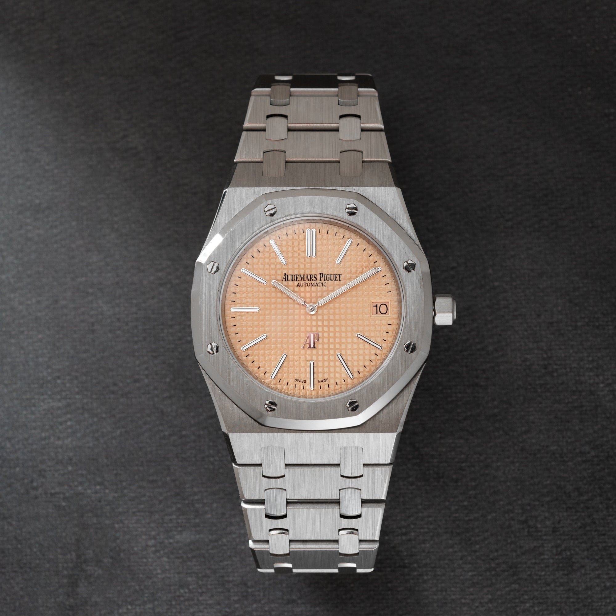 Stainless steel Audemars Piguet Royal Oak watch with salmon dial, applied indices, and integrated bracelet.
