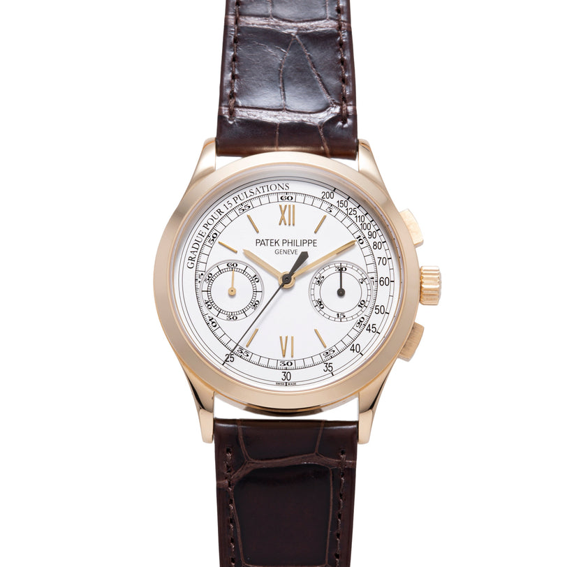 Rose gold chronograph watch with white dial, Roman numerals, two subdials, and dark brown leather crocodile strap.