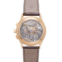 Gold-tone chronograph watch with visible skeletal movement, brown leather strap, and exhibition caseback.
