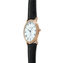 Rose gold watch with white dial, Roman numerals, subsidiary seconds dial, and black leather strap.