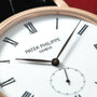 Rose gold Patek Philippe Calatrava watch with white dial, Roman numerals, and small seconds subdial.