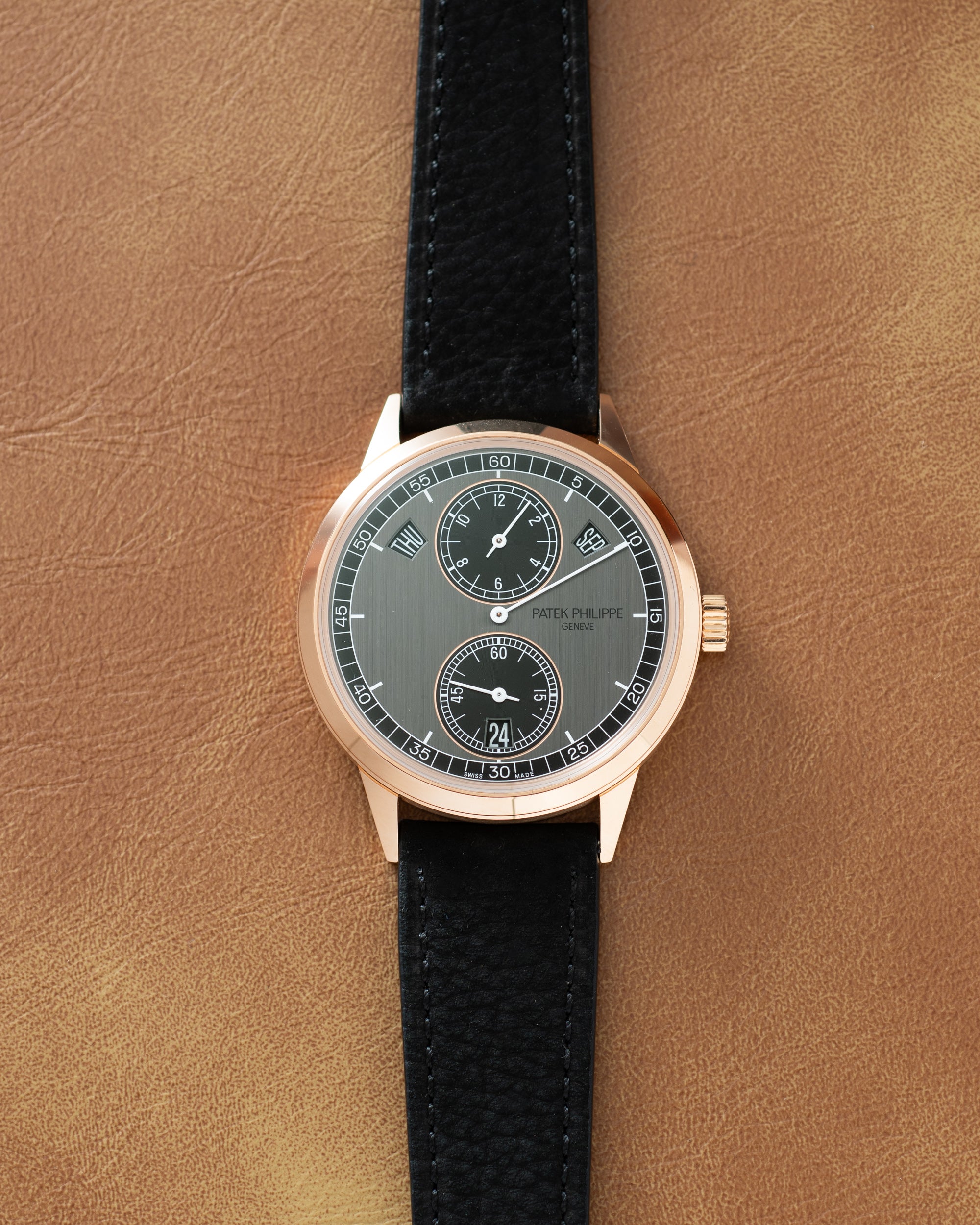 Patek Philippe wristwatch with rose gold case, grey dial, two subsidiary dials, and black leather strap.