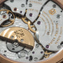Patek Philippe movement with gold and silver gears, jewels, and engraved bridges showing regulator complications.