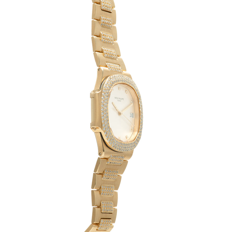 Gold-tone Nautilus watch with diamond-set bezel, cream dial, and matching diamond-paved bracelet links.