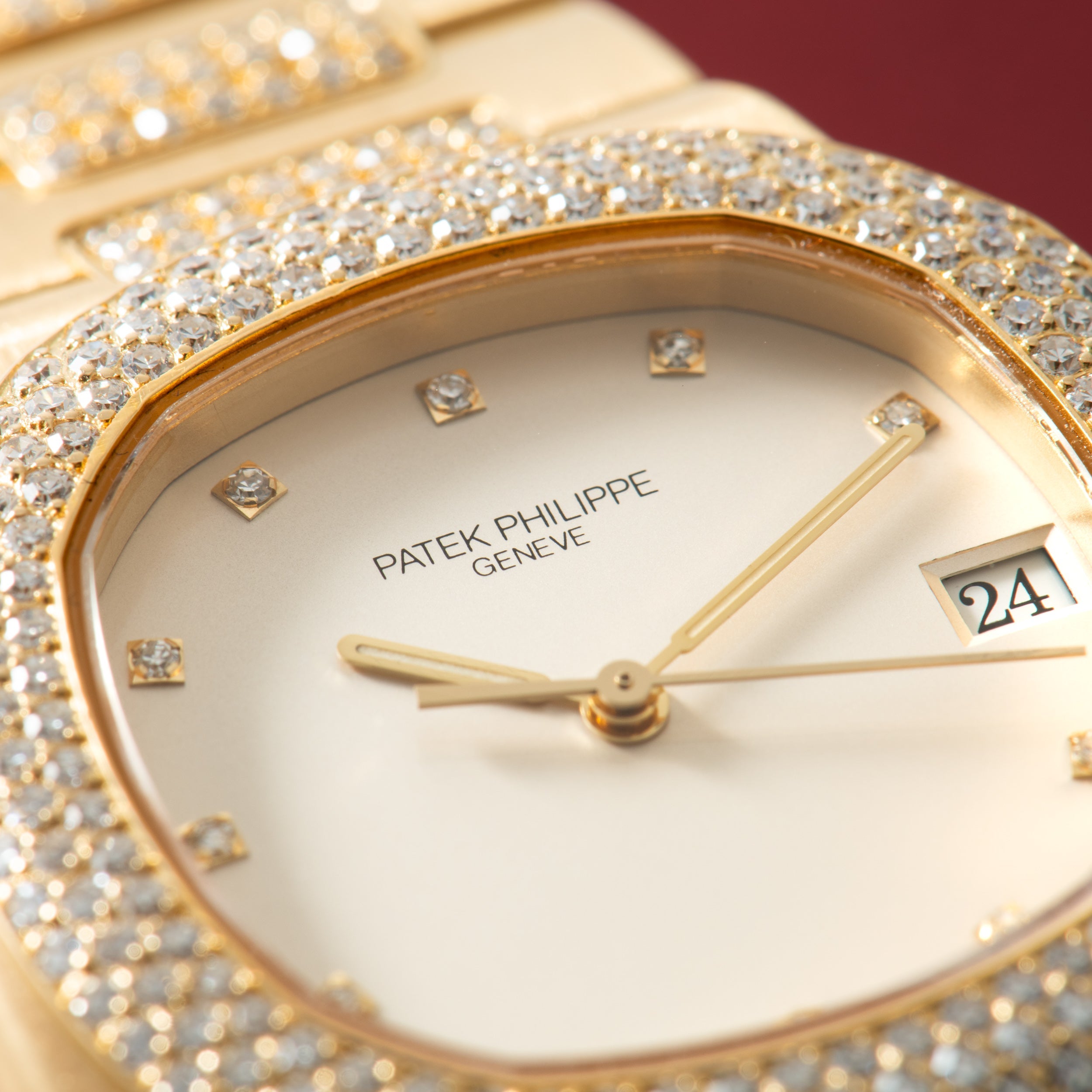 Gold-tone watch with diamond-set bezel, white dial, diamond hour markers, gold hands, and date window.