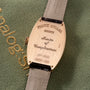 Franck Muller Master of Complications watch with rose gold tonneau case and gray leather strap.