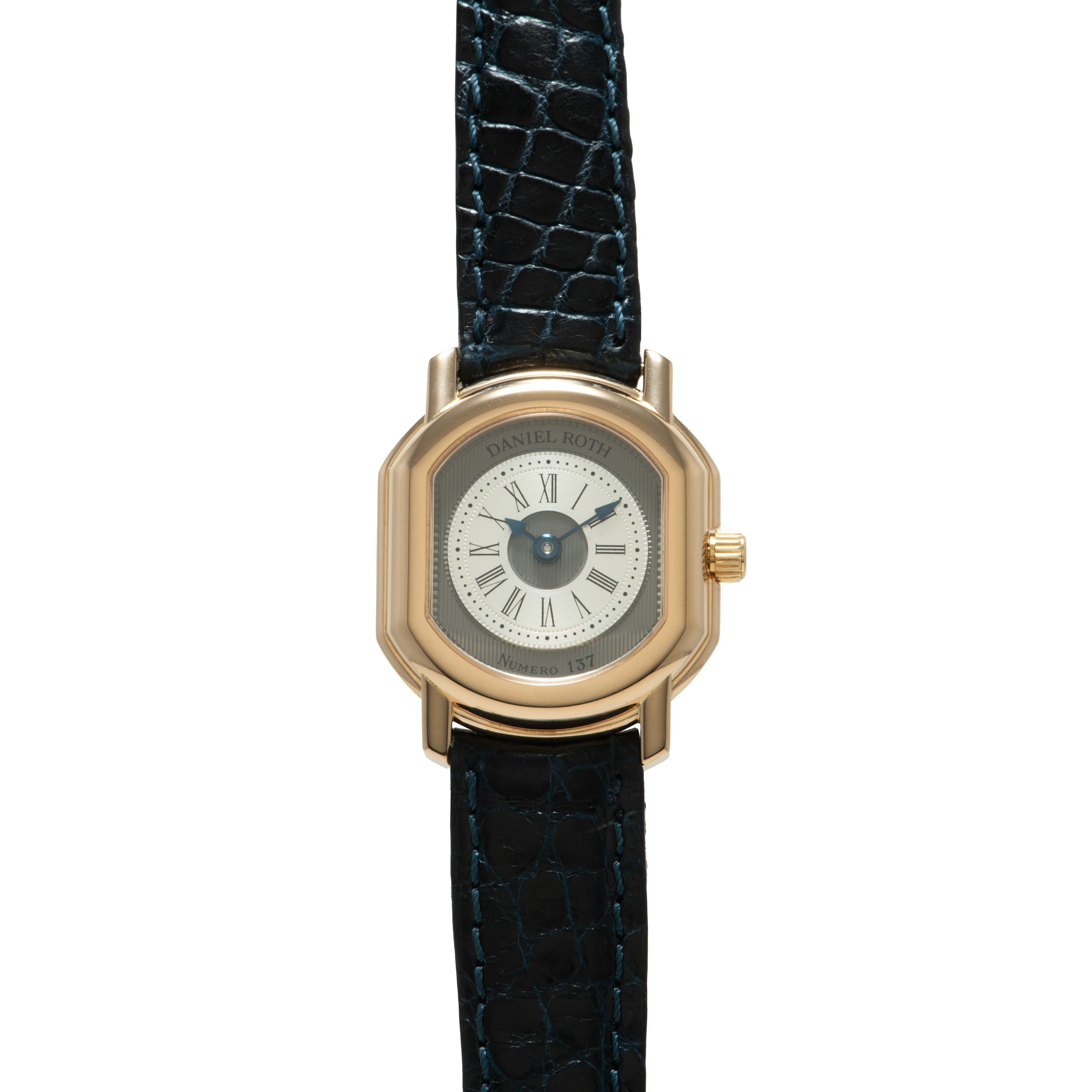 Gold-tone square watch with cream dial, Roman numerals, and dark blue crocodile leather strap.