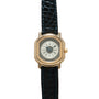 Gold-tone square watch with cream dial, Roman numerals, and dark blue crocodile leather strap.