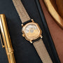 Rose gold octagonal watch with black leather strap and visible mechanical movement through transparent caseback.