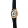 Gold-tone rectangular watch with cream dial, Roman numerals, and dark blue crocodile leather strap.