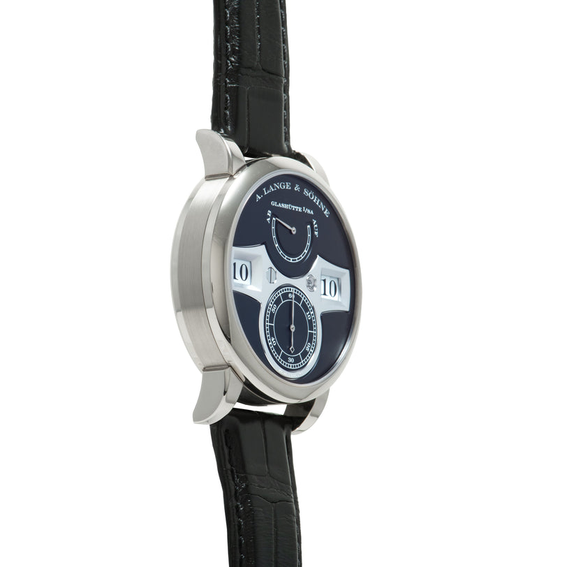 Silver-cased watch with dark blue dial, white jumping hour numerals, subsidiary dials, and black leather strap.