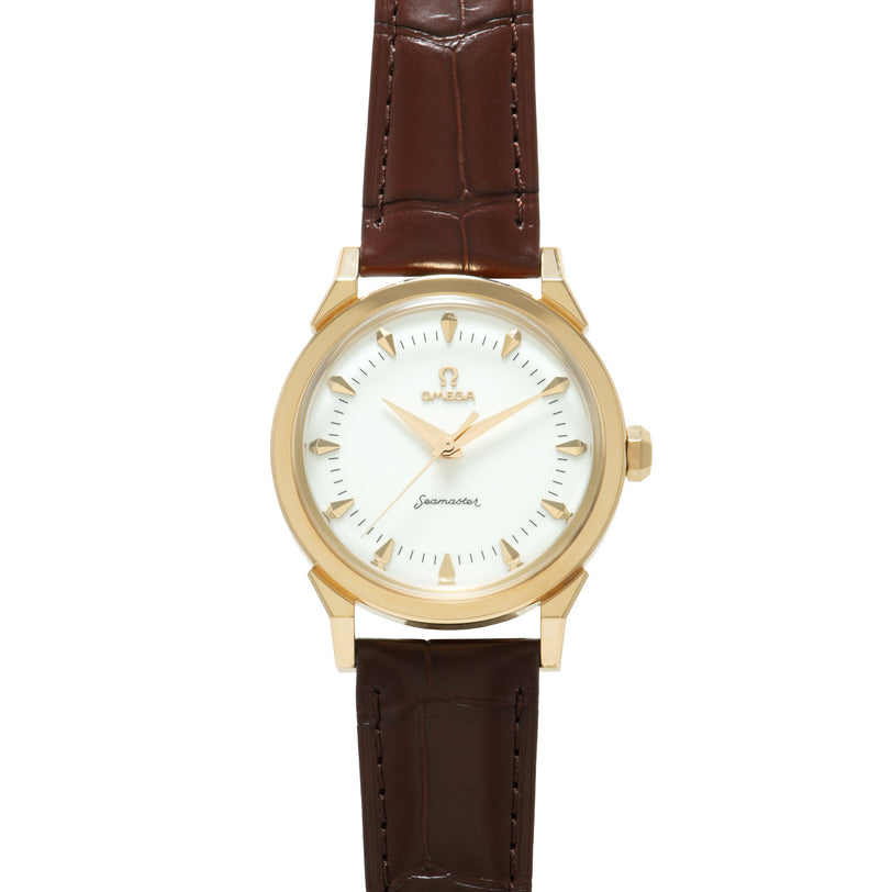 Omega Seamaster watch with gold-tone case, cream dial, gold hour markers, and brown leather strap.
