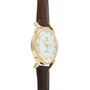 Gold-tone watch with white dial, applied hour markers, and brown leather crocodile-textured strap.