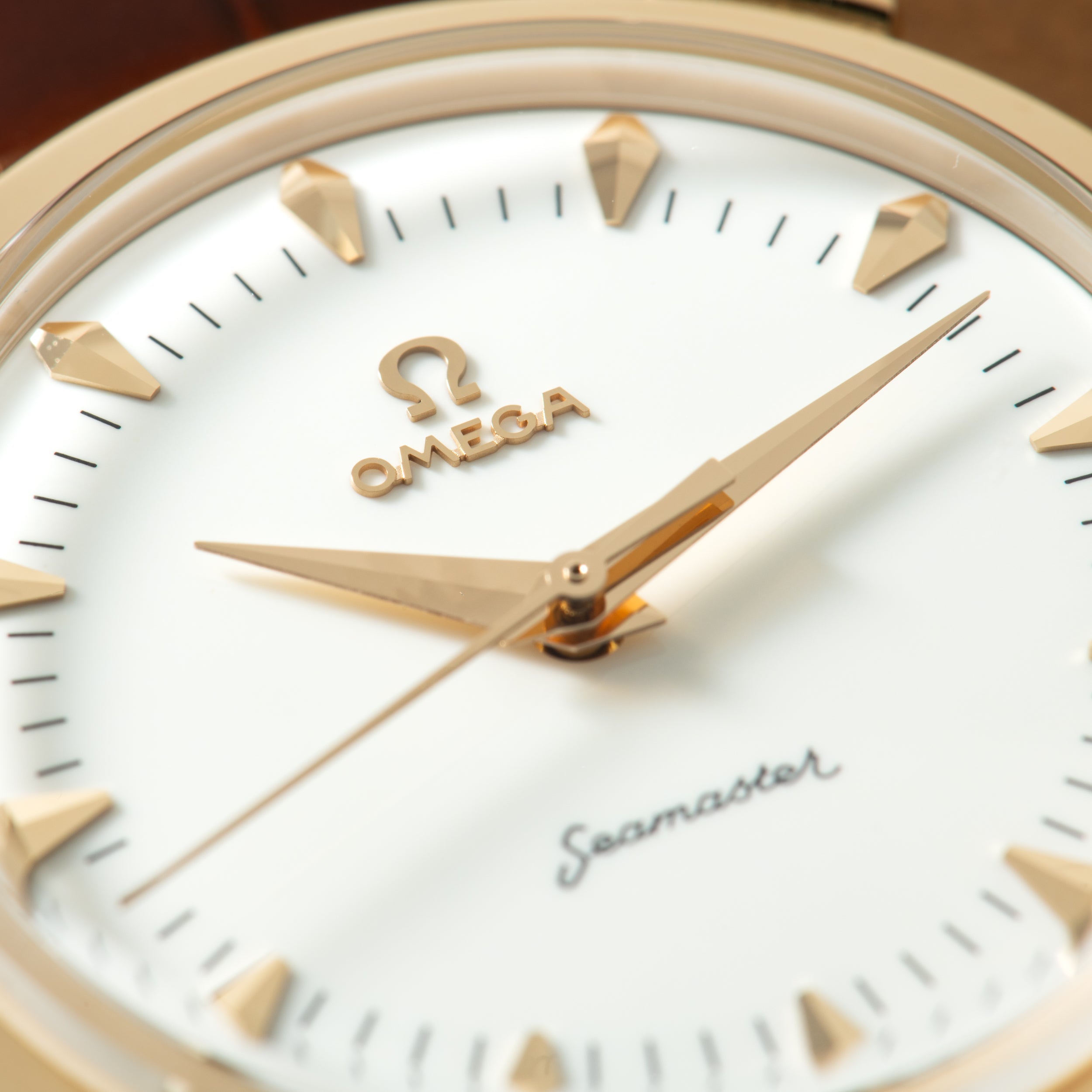Omega Milano Cortina watch with white dial, gold-tone hour markers and hands, black minute indices, and Omega logo visible on