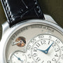 F.P. Journe Chronomètre Optimum watch with silver case, cream dial, blue hands, power reserve indicator, and black leather st